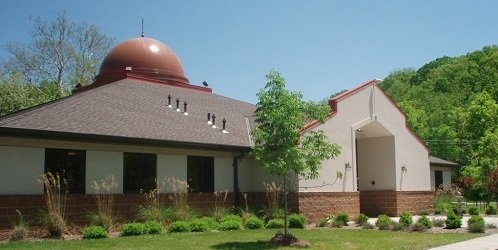 The Center's building with its copper dome, surrounded by trees